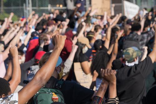 Protestors raise their hands in solidarity outside of the Fifth Police Precinct in Minneapolis in response to the death of George Floyd