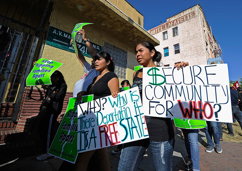 Protesters with Coalition for Humane Immigrant Rights of Los Angeles (CHIRLA) hold signs as they march during an anti Secure Communities program demonstration on August 15, 2011 in Los Angeles, California. 